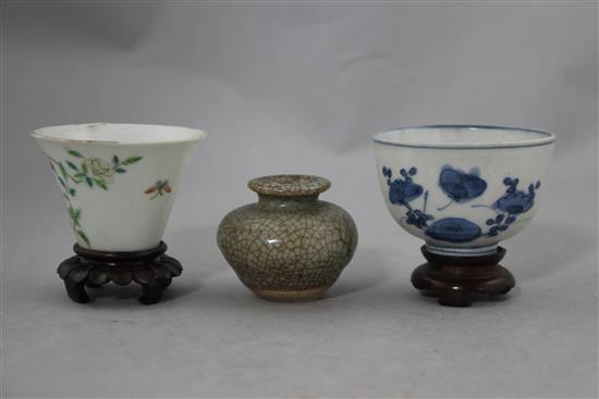 Two Chinese porcelain cups and a small crackle glaze vase, 17th - 19th century, 4.8cm., with wood stand